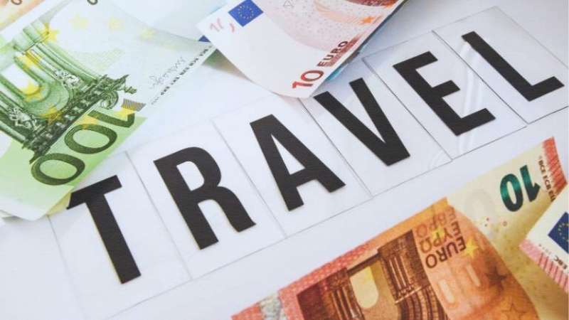 Travel Text on flat surface with Euro Notes surrounding the word showing money and travel